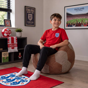 Boy relaxing on the Match Day Football Pouffe in an England fan bedroom
